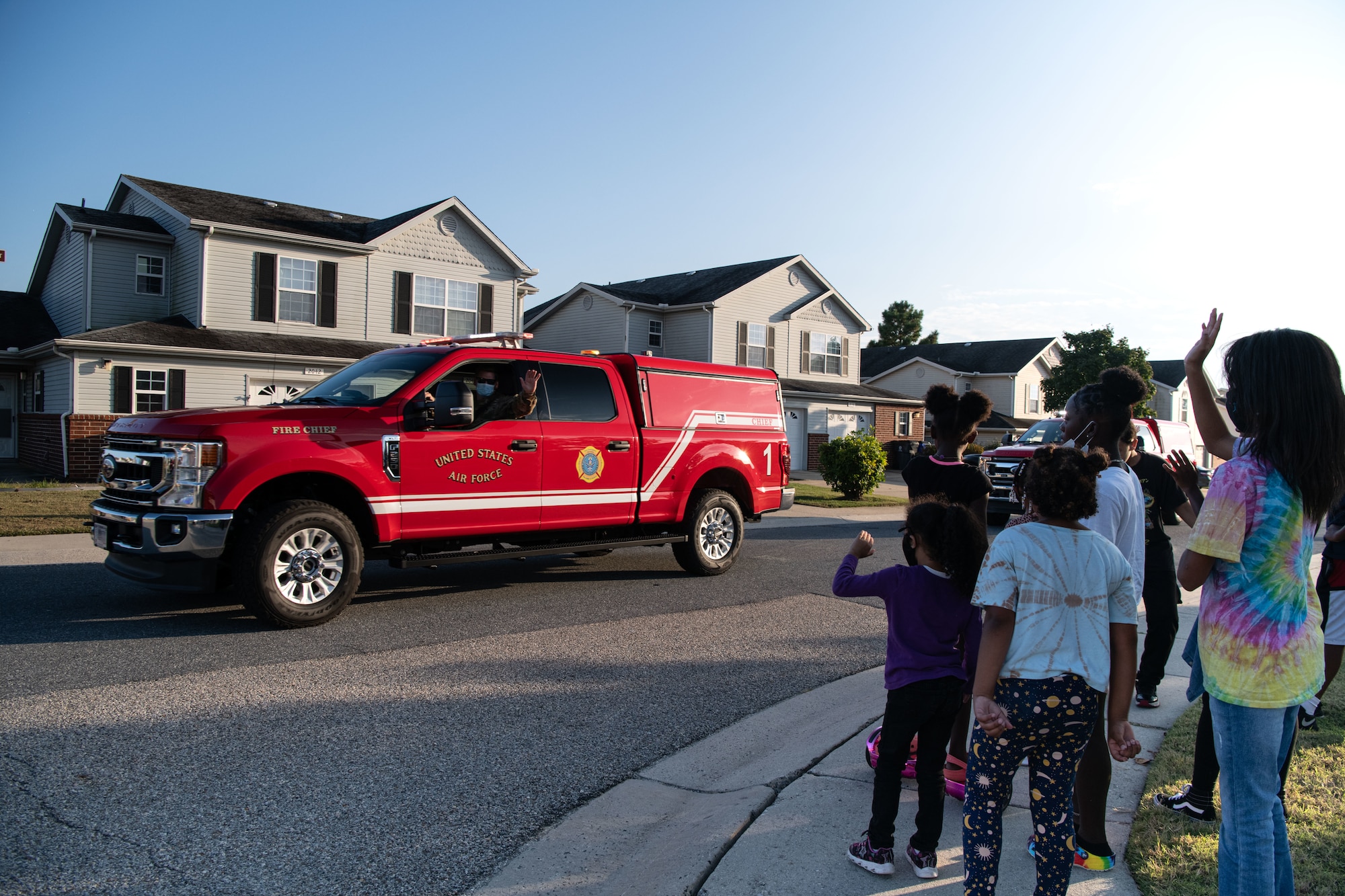 Children wave at a firefighter during the 2021 Fire Prevention Week Parade on Dover Air Force Base, Delaware, Oct. 15, 2021. Airmen from the 436th Civil Engineer Squadron drove emergency response vehicles through base housing to spread awareness on fire safety. (U.S. Air Force photo by Senior Airman Marco A. Gomez)
