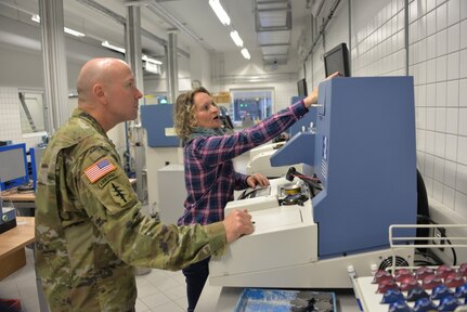 Yvonne Gortner, prescription eyeglass maker supervisor for the U.S. Army Medical Materiel Center-Europe, examines a custom lens to make certain it is correctly ground. Gortner has been with USAMMCE since 2003, beginning as an optician.