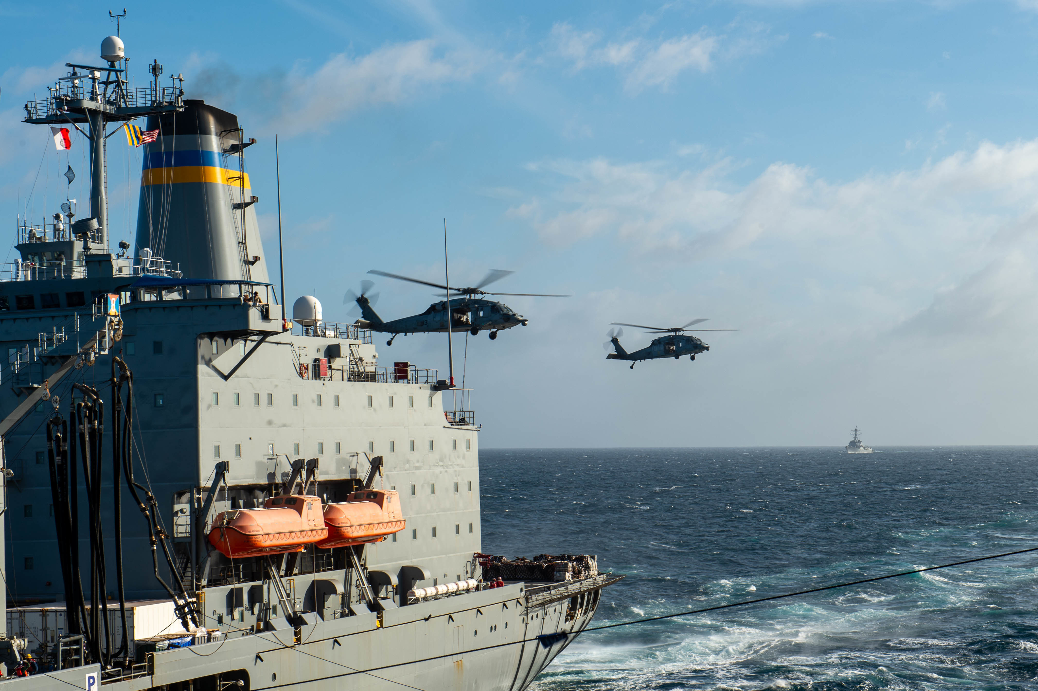 MH-60S Sea Hawks, assigned to the “Black Knights” of Helicopter Sea Combat Squadron (HSC) 4, transfer cargo between Henry J. Kaiser-class fleet replenishment oiler USNS Yukon (T-AO 202) and Nimitz-class aircraft carrier USS Carl Vinson (CVN 70) during a replenishment-at-sea during Maritime Partnership Exercise 2021, Oct. 18, 2021.