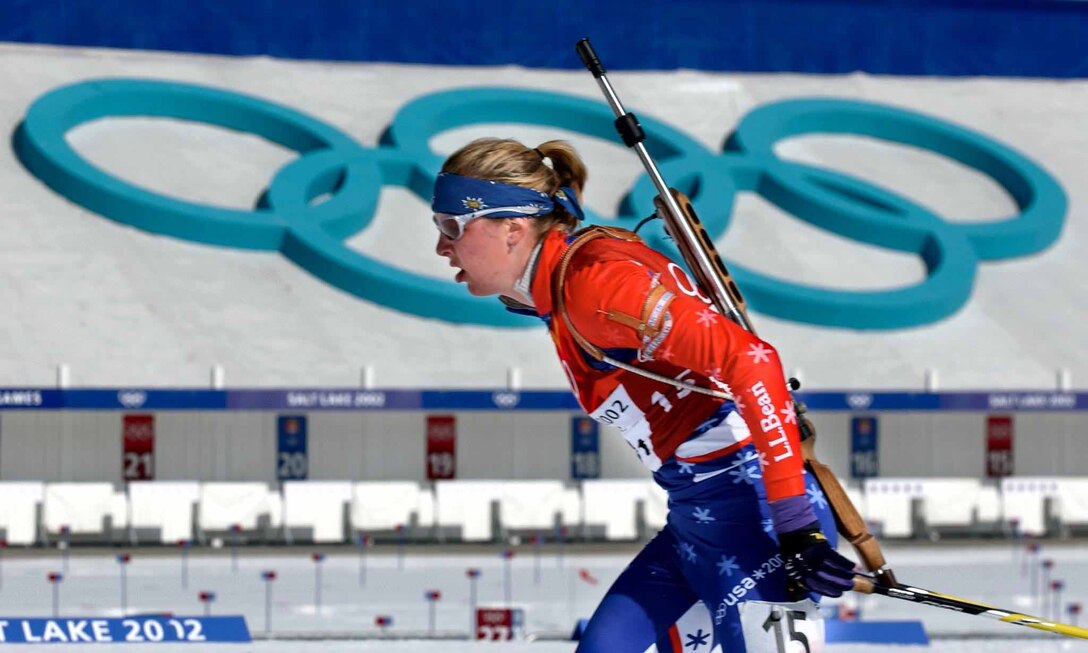 Woman with rifle skis.