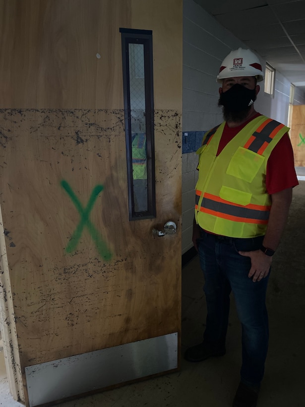 6 foot tall Matt Stivers stands next to waterline on classroom entryway