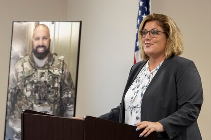 Theresa Smith, Defense Ammunition Center executive director, recalls the life of Michael G. Sauro, a former DAC hazardous material instructor who lost his life while deployed as a civilian in support of Operation Freedom’s Sentinel, during a building dedication ceremony at Camp Atterbury, Ind., June 3, 2021. During her speech, she quoted Sauro’s sister, Brianne Matthews, who said, “Mike died doing a job he loved for a country he loved even more.” (U.S. Army photo by Mark R. W Orders-Woempner)