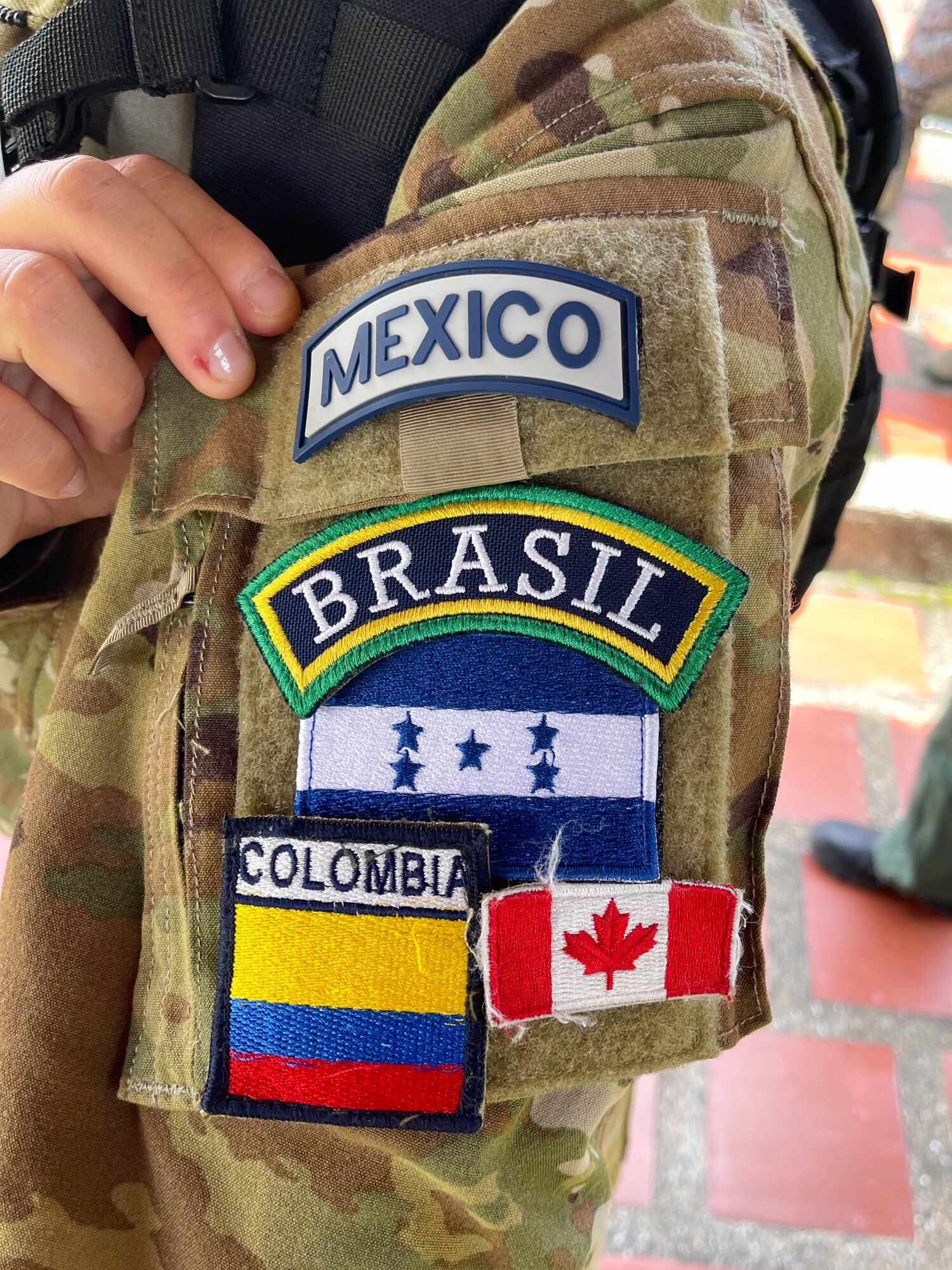 Rionegro, Colombia - Reserve Citizen Airman Lt. Col. Heleno Souza, 944th Aeromedical Staging Squadron chief administrator, shows off several patches from partner countries, at Jose Maria Cordova International Airport in Colombia, Sept. 9, 2021. Souza collected these patches while participating in “Angel de los Andes,” a two-week multinational, Colombian led exercise Aug. 30-Sept 10 that focuses on international search and rescue, humanitarian assistance, disaster relief, and aerial evacuation. (Courtesy photo by Souza)