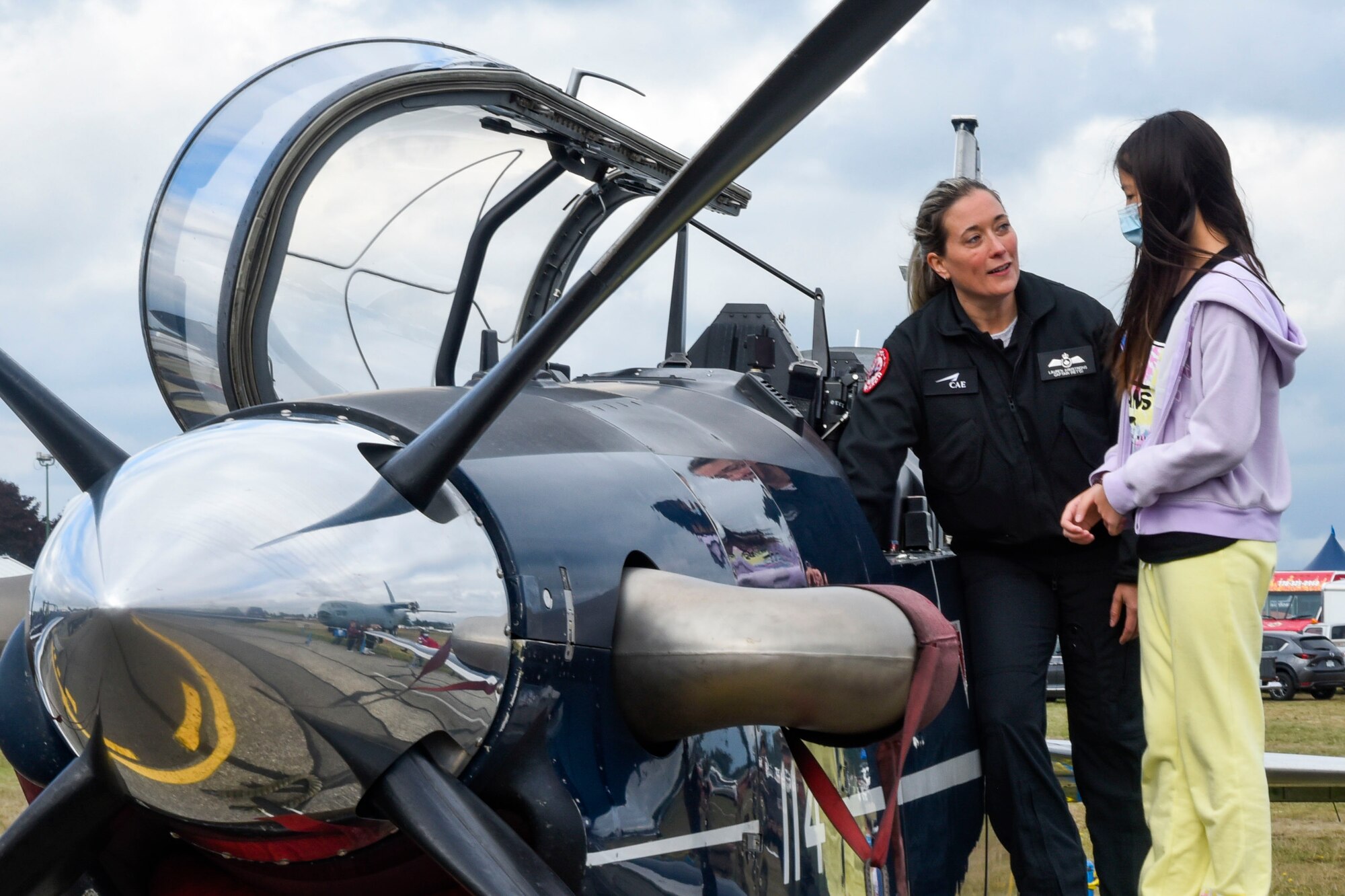 A Royal Canadian Air Force Instructor Pilot teaches a young girl about a trainer aircraft during “The Sky’s No Limit: Girls Fly Too” event in Abbotsford, Canada, Oct. 3, 2021.The event gave Airmen from Fairchild an opportunity to empower young ladies, and inspire them to pursue various career opportunities. (U.S. Air Force photo by 2nd Lt. Michelle Chang)