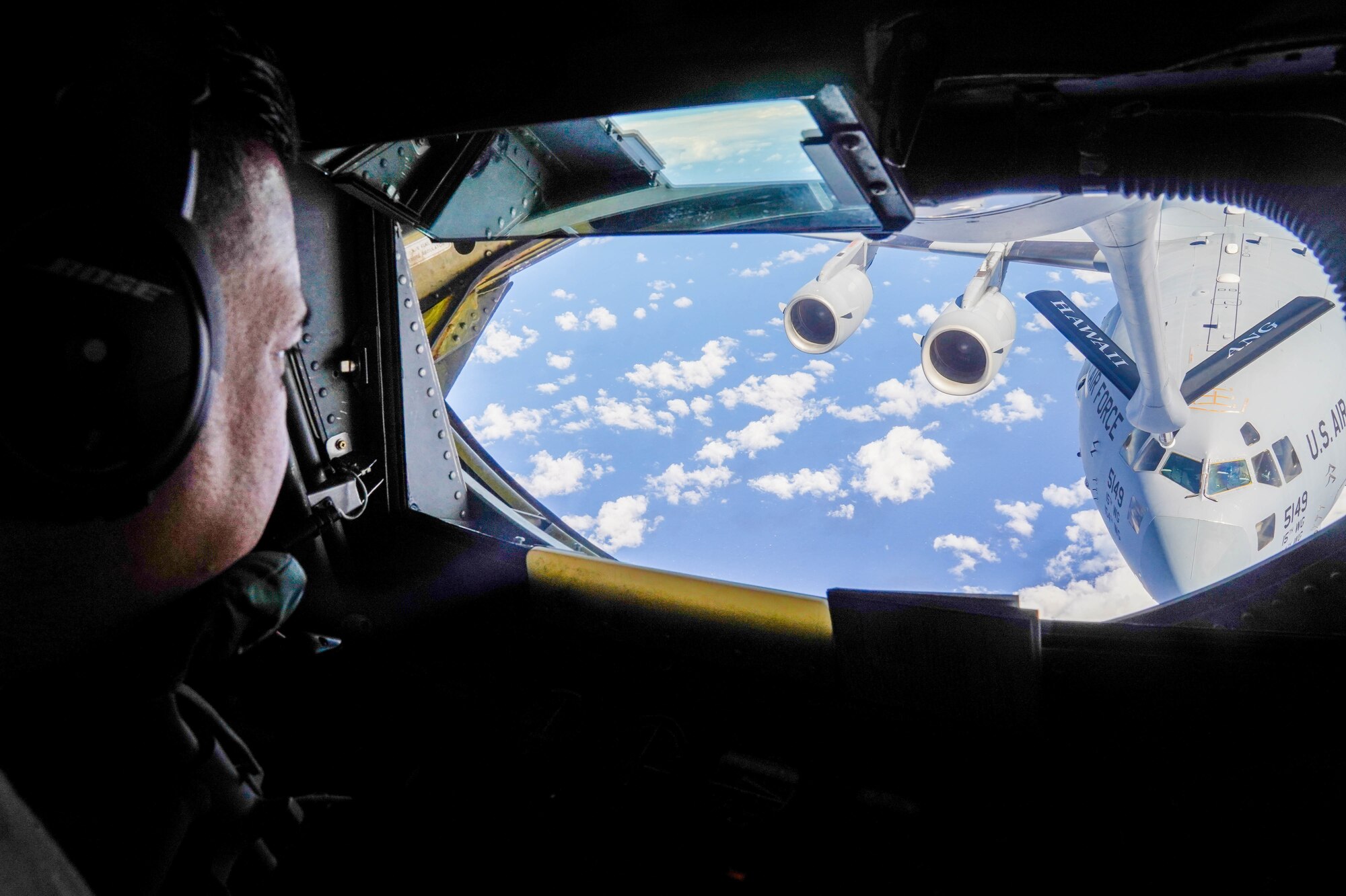 Master Sgt. Cal Codeiro, 203d Airlift Squadron, boom operator, refuels a C-17 Globemaster III during a refueling exercise around the Hawaiian Islands, October 18, 2021. The boom operator is stationed in the rear of the fuselage operating a boom to refuel aircraft in flight practicing air refueling readiness. (U.S. Air Force photo by Airman 1st Class Makensie Cooper)