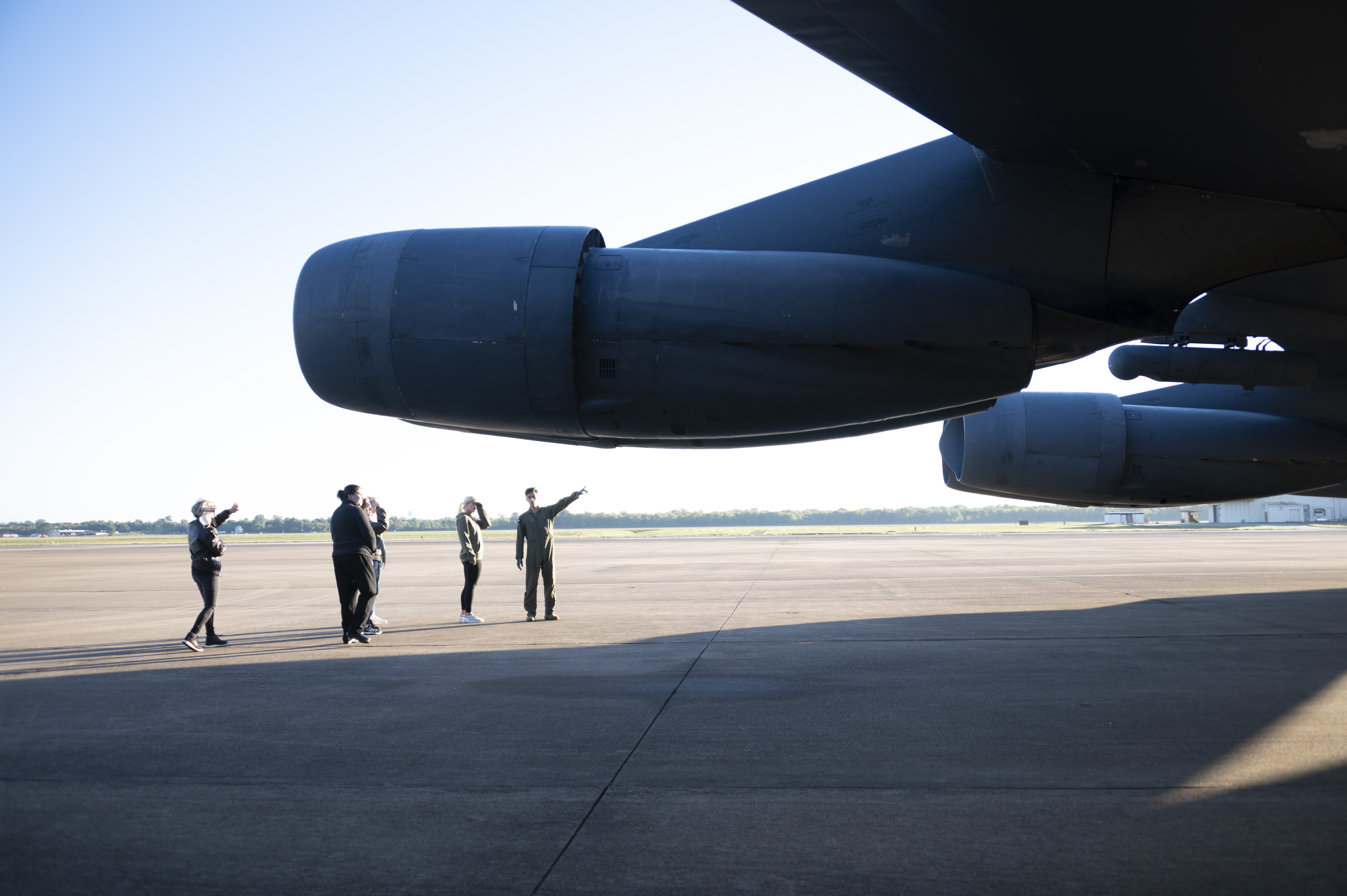 People gather underneath wing of a B-52