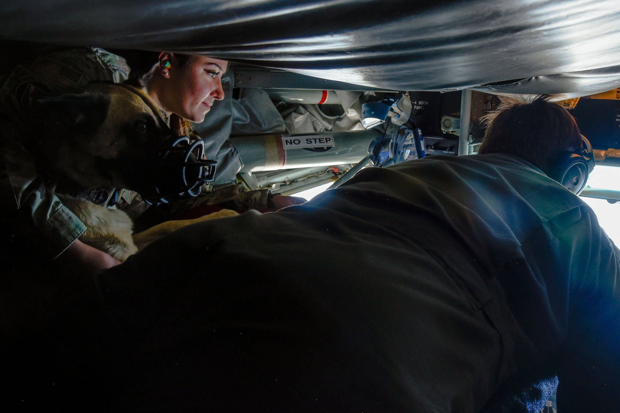 U.S. Air Force Staff Sgt. Crystal Maldonado, 92nd Security Forces Squadron Military Working Dog handler, and Military Working Dog Lilli, observe Master Sgt. Lauren Powell, 93rd Air Refueling Squadron boom operator, as she conducts aerial refueling aboard a KC-135 Stratotanker while on route to “The Sky’s No Limit: Girls Fly Too” event in Abbotsford, Canada, Oct. 1, 2021. The event gave Airmen from Fairchild an opportunity to empower young ladies, and inspire them to pursue various career opportunities. (U.S. Air Force photo by 2nd Lt. Michelle Chang)