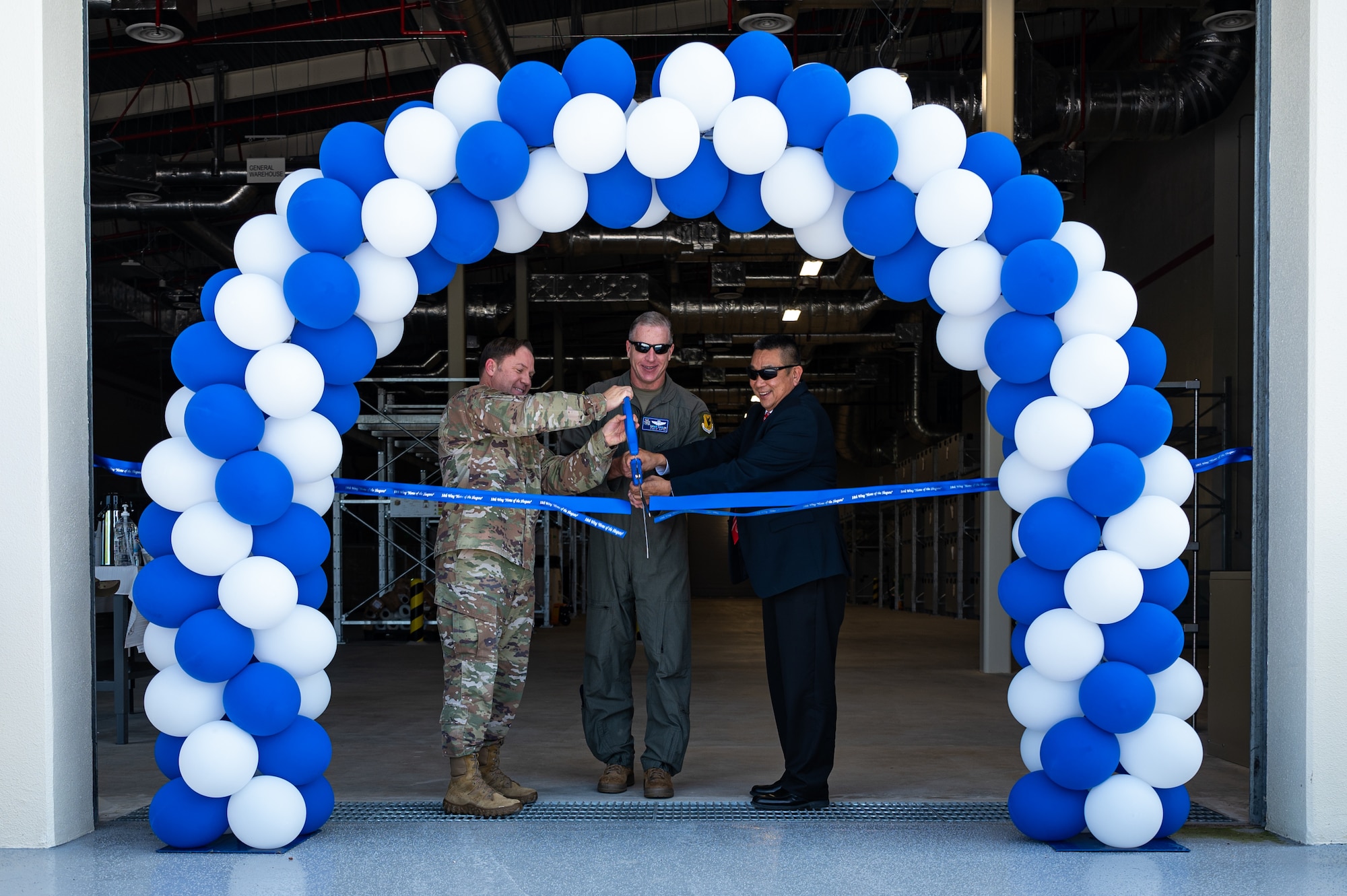 Col. Veeder, Brig. Gen. Eaglin and Triet Bui cut ribbon for an opening ceremony.