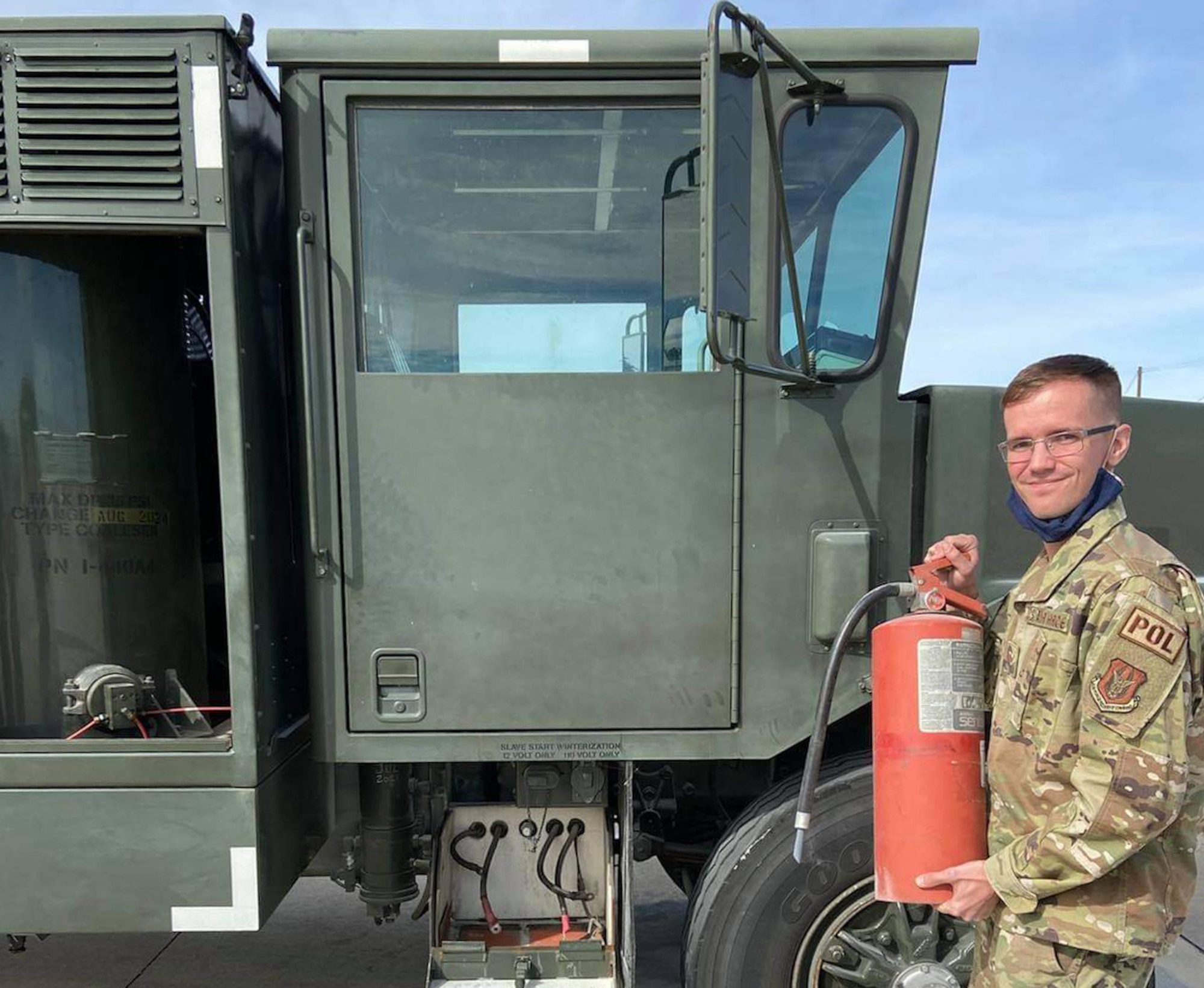 Senior Airman Matthew Kunko, 301 FW Logistics Readiness Squadron fuels operations specialist, stands in front of the fuel delivery truck with the fire extinguisher he used to put out a vehicle fire at Naval Air Station Joint Reserve Base Fort Worth, Texas on Oct. 17, 2021. Kunko detected a burning smell burning he started one of the LRS fuel delivery trucks and extinguished the fire saving the truck and potentially two additional lives. (courtesy photo)