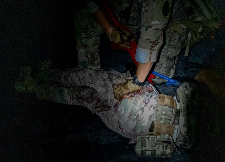 Soldier applies pressure to a simulated gunshot wound on a simulated casualty.