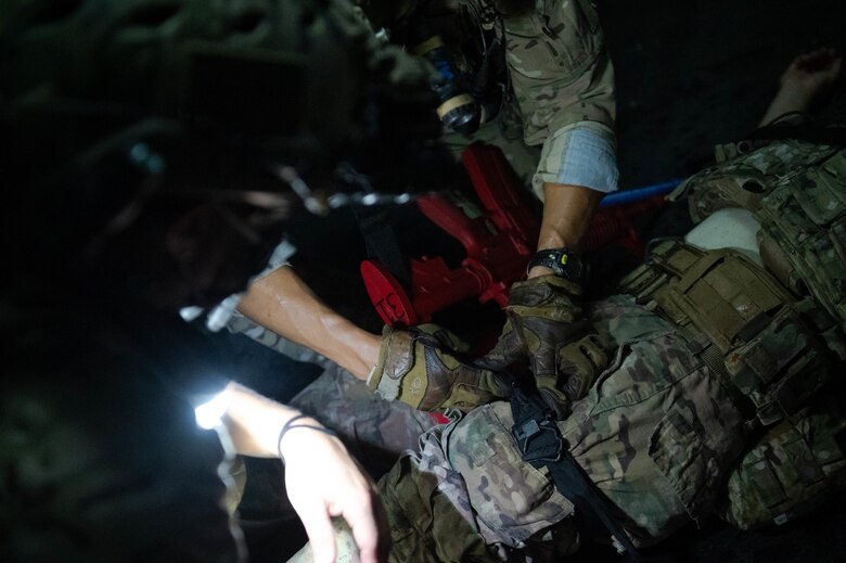 Soldier places a tourniquet on a simulated casualty.