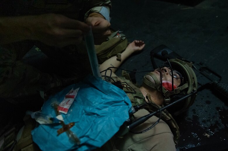 Portrait of simulated casualty receiving medical care.