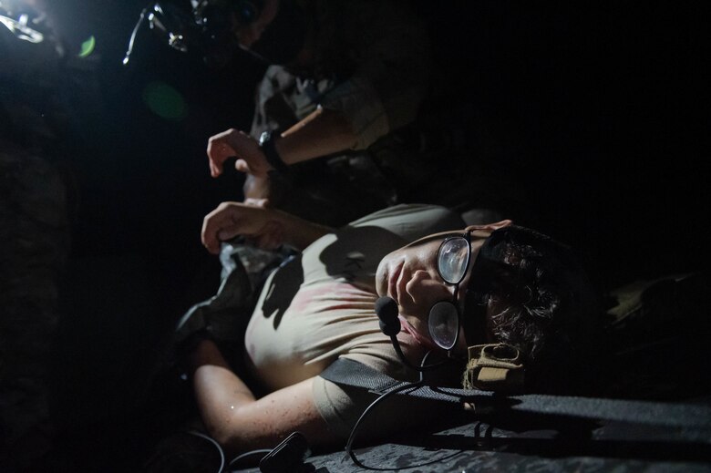 Soldier checks the pulse of a simulated casualty.