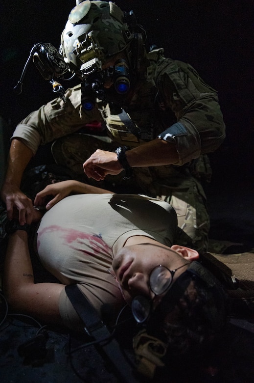 Soldier checks the pulse of a simulated casualty.