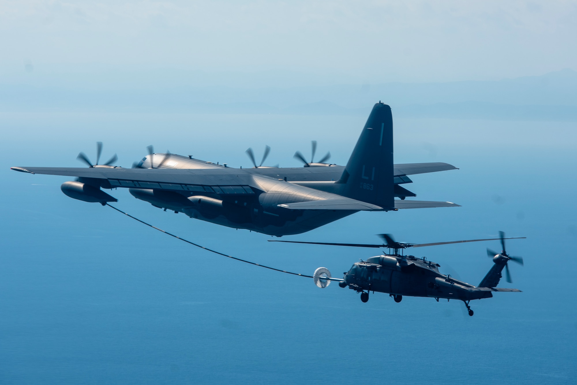 A KC-135 Stratotanker refuels an HH-60G Pave Hawk during a combat search and rescue training event