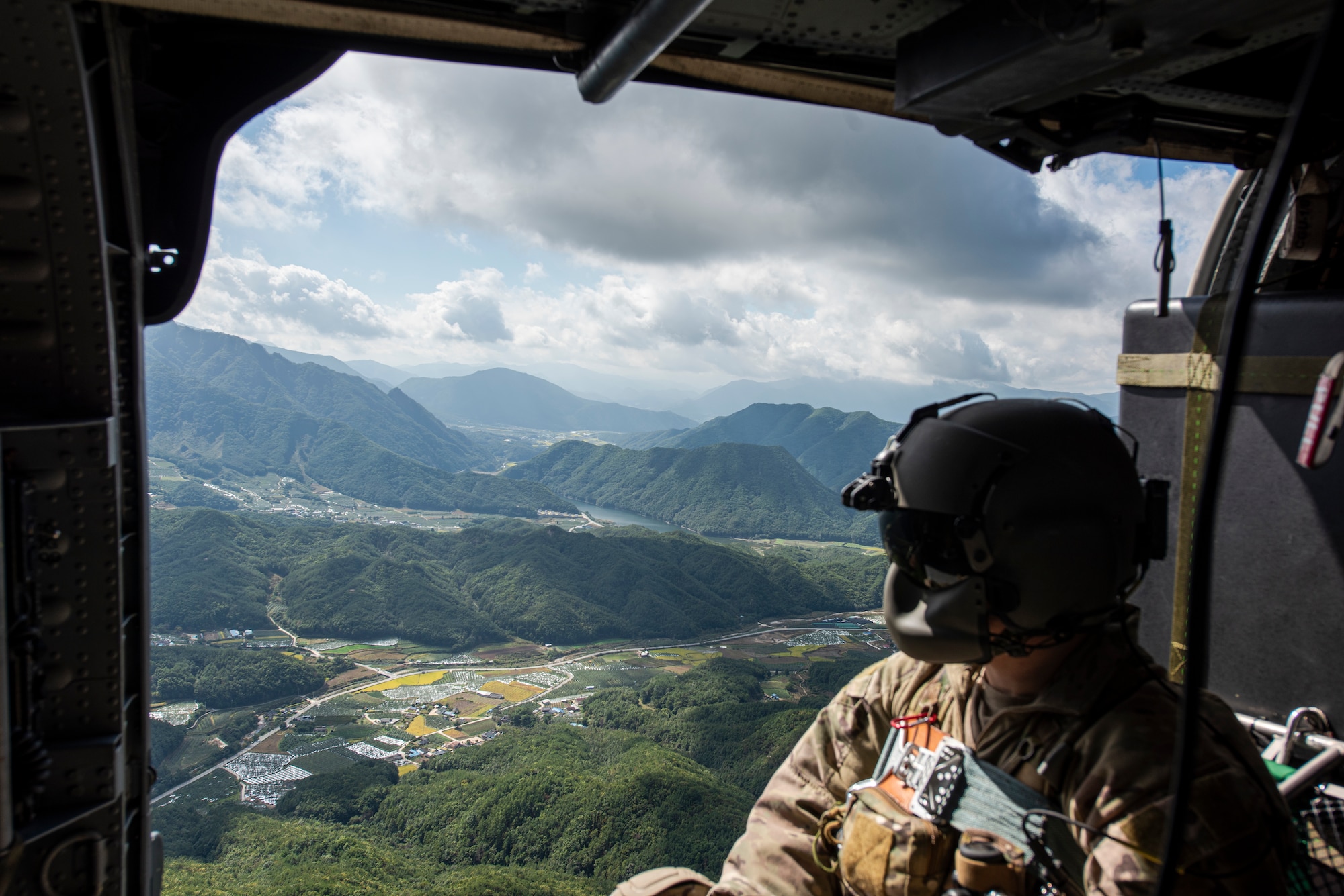 Senior Airman Eaven Allison, 33rd Rescue Squadron special missions aviator, looks out over the landscape from inside an HH-60G Pave Hawk helicopter during a combat search and rescue training event