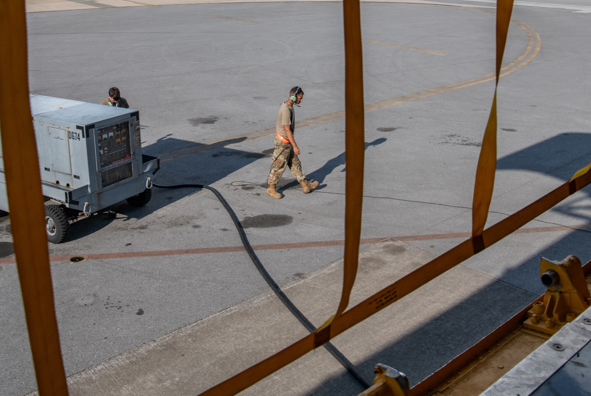 Two Airmen walk next to a KC-135 aircraft.