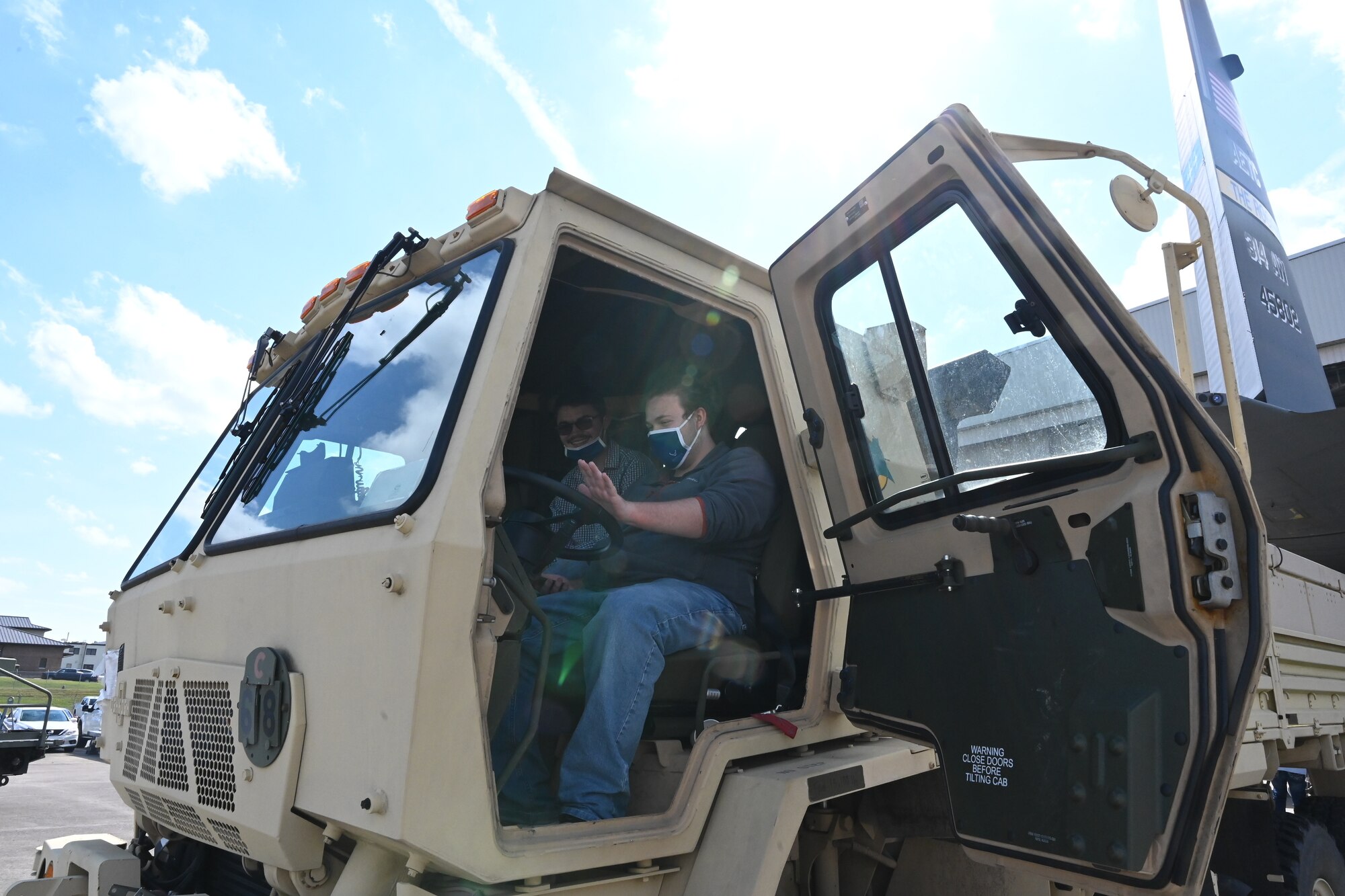 A student sits in a military vehicle