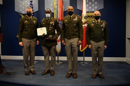 group of soldiers with awards standing on a stage.