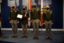 group of soldiers with awards standing on a stage.