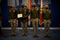 group of soldiers with awards standing on a stage.