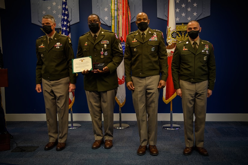 group of soldiers with awards standing on a stage.