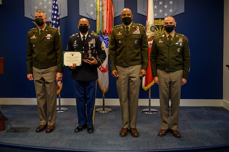 group of soldiers with awards standing on a stage.