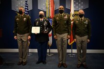 group of soldiers with awards standing on a stage.