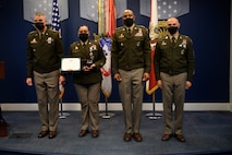 group of soldiers with awards standing on a stage.