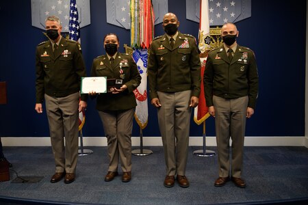 group of soldiers with awards standing on a stage.