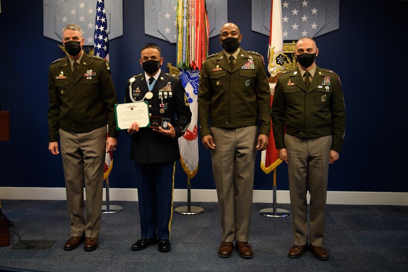 group of soldiers with awards standing on a stage.