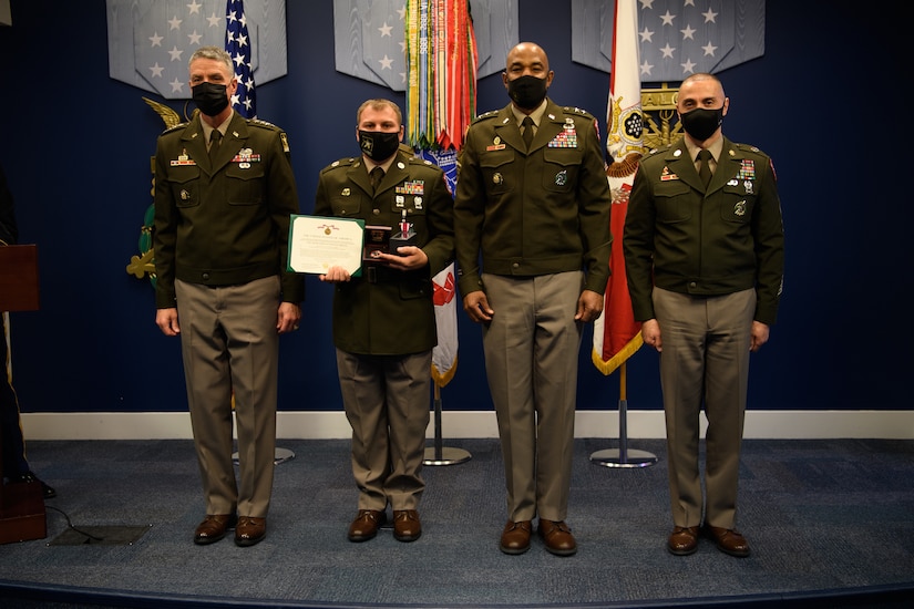 group of soldiers with awards standing on a stage.