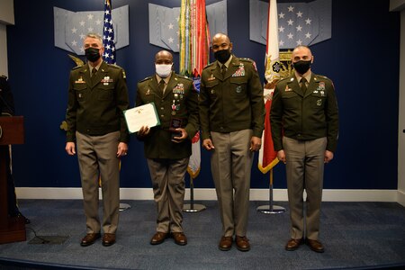group of soldiers with awards standing on a stage.