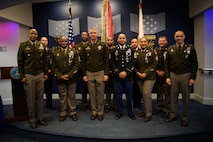 group of soldiers with awards standing on a stage.