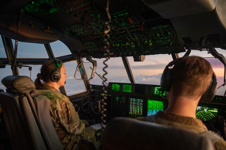 Two Airmen pilot a C-130J