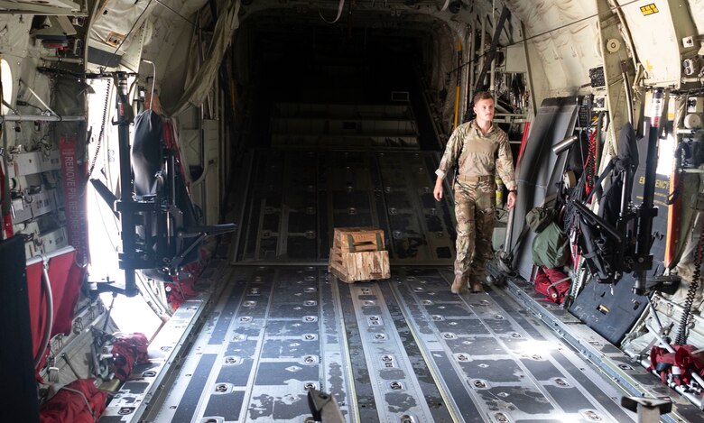 An Airman walks in the cargo bay of a C-130J
