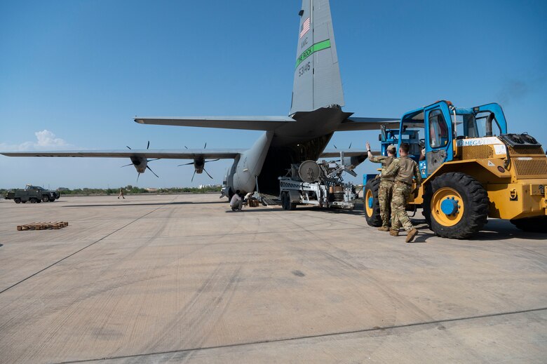 Airmen load cargo onto a C-130J