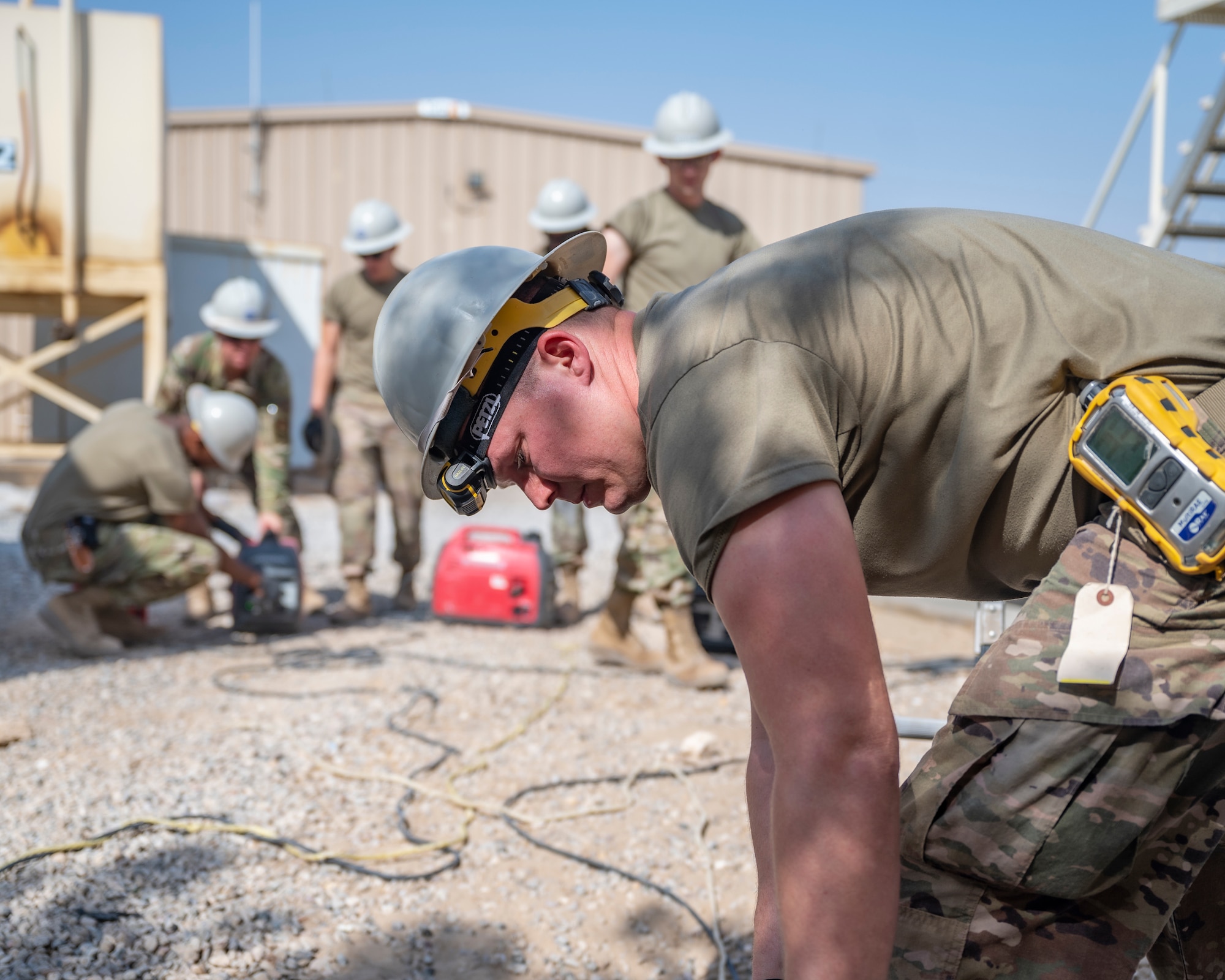 A member of the U.S. Air Forces Central, Air Force Forces A67 Engineering and Installation team checks equipment as his teammates start a generator at Ali Al Salem Air Base, Kuwait, Oct. 19, 2021.