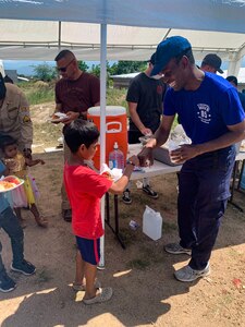 U.S. Air Force Maj. Kennie Neal, Joint Task Force Bravo (JTF-B) command chaplain, bumps fists with a local boy in a neighborhood of La Paz, Honduras, during a volunteer event, Oct. 17, 2021.