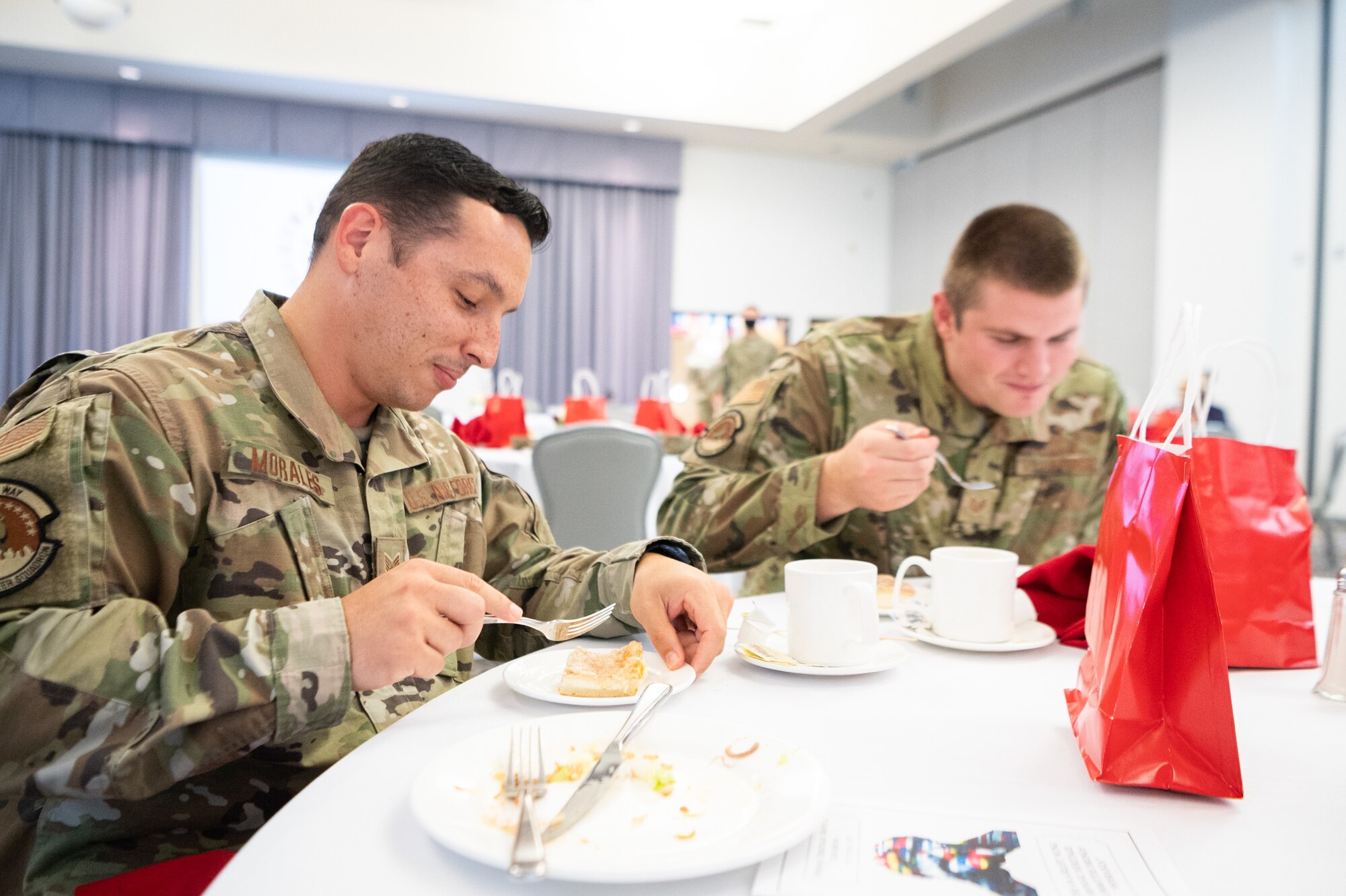 Staff Sgt. Jahleel Morales Cabrera, left, 436th Civil Engineer Squadron engineers journeyman and Tech Sgt. Marcell Ruijne, 436th CES engineering noncommissioned officer in charge, eat dessert during the Hispanic Heritage Month Luncheon at Dover Air Force Base, Delaware, Oct. 15, 2021. The luncheon featured traditional hispanic food and music along with two guest speakers. (U.S. Air Force photo by Mauricio Campino)