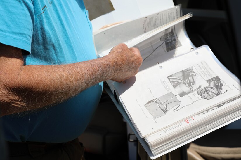 Retired Lt. Col. Dick Stoops checks the techical manual on a M114A2 Howitzer on Boone National Guard Center in Frankfort, Ky on May 10, 2021.  Stoops restored the decommissioned gun during the summer of 2021 (U.S. Army photo by U.S. Army Sgt. Jesse Elbouab).