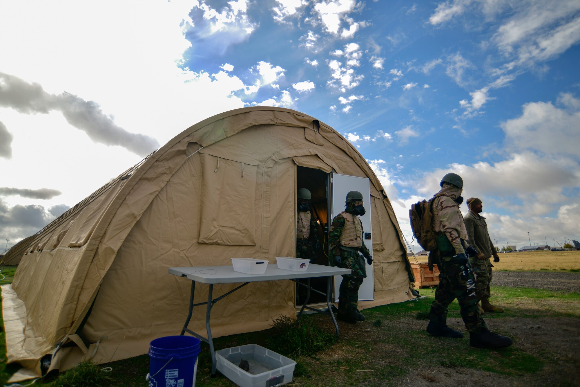 U.S. Air Force Airmen from Team Fairchild exit a shelter during a large readiness exercise at Fairchild Air Force Base, Washington, Oct. 6, 2021. The training required Airmen to conduct a post-attack reconnaissance sweep during the exercise. (U.S. Air Force photo by Senior Airman Ryan Gomez)