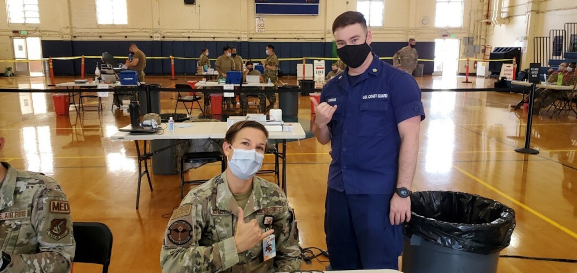 Petty Officer Second Class, Andrew Simons, a health services technician (right), assists Air Force Maj. Katherine Rorer (left) at the Tripler Army Medical Center, Hawaii, during Tripler’s MHS GENESIS “go-live” mass vaccination evolution on Sept. 28. Simons recently participated in the Coast Guard's MHS GENESIS PACWAVE “go-live” on Aug. 21 at Coast Guard Base Honolulu and was able to lend his electronic health records experience to the event.