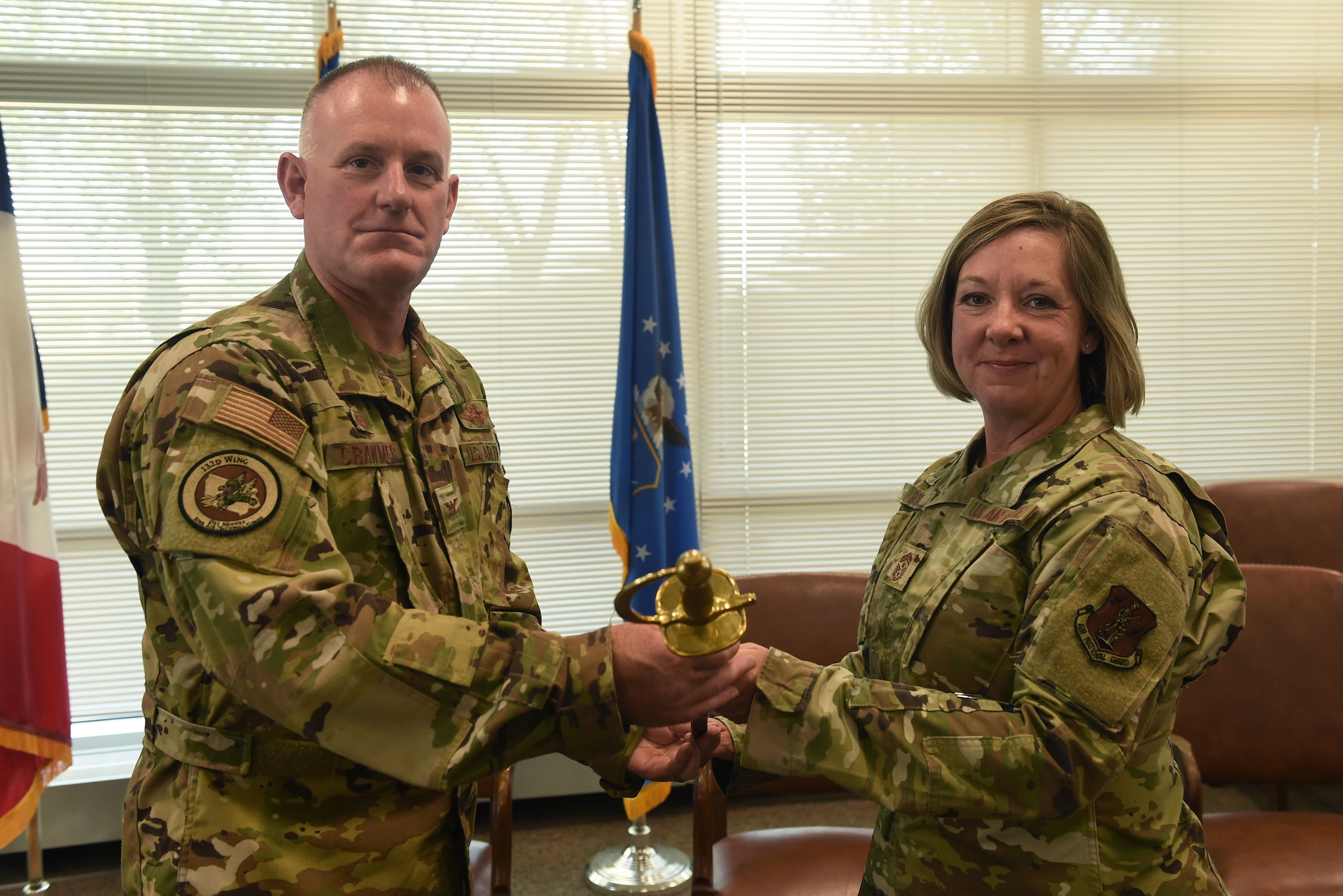 Col. Travis Crawmer (left) and Chief Master Sgt. Kris Rode (right) pose for a photo with the ceremonial chief's saber during the change of command ceremony held on September 19th, 2021 at the 132d Wing, Iowa Air National Guard, Des Moines, IA.
