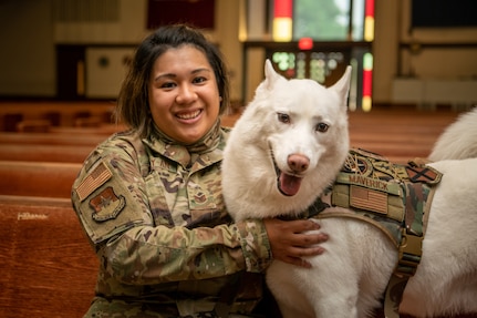 Maverick, a Siberian Husky who functions as the chapel dog for the 502nd Air Base Wing Chaplain Corps, poses with his handler, Tech. Sgt. Karen Pasay-an, the noncommissioned officer in charge of Installation Ministries at the Gateway Chapel, Oct. 12, 2021, Joint Base San Antonio - Lackland, Texas.