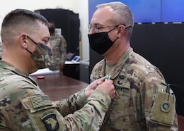 1st Theater Sustainment Command Deputy Commanding Officer Col. Sean P. Davis awards Chief Warrant Officer 4 Scott O. Harned, 1st TSC (Forward), the Army Commendation Medal with the "C" device for combat conditions during an Oct. 7, 2021, presentation held at the 1st TSC's operational command post, Camp Arifjan, Kuwait. Harned earned the medal for his July 28, 2021 to Aug. 30, 2021 deployment to Afghanistan to support U.S. forces in the last days of the U.S. military operations there.
