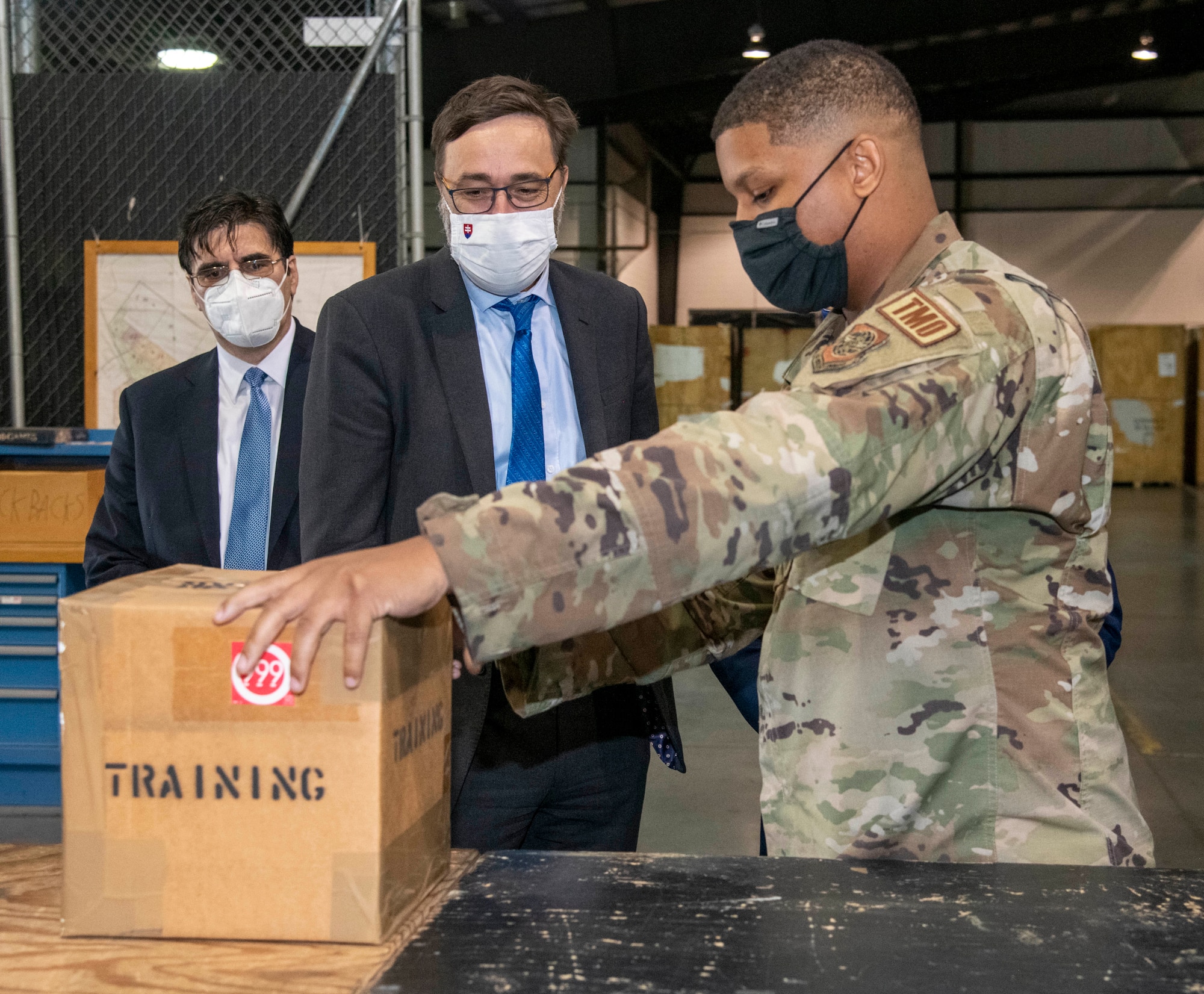 Senior Airman Adam Porter, right, 436th Aerial Port Squadron intransit cargo specialist, shows Slovakian Ambassador to the United States, Radovan Javorčík, middle, and Bulgarian Ambassador to the U.S., Tihomir Stoytchev, how the 436th APS transports cargo around the world during a visit to Dover Air Force Base, Delaware, Oct. 18, 2021. Porter also showcased the squadron’s capabilities with making customized boxes required to ship anything from tires to household goods. (U.S. Air Force photo by Tech. Sgt. Nicole Leidholm)