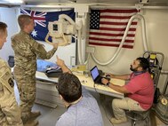 Fernando González-Rodríguez, right, lead electronic technician with the U.S. Army Medical Materiel Agency’s Forward Repair Activity-Medical (FRA-M) team, walks Sgt. Joseph Black, 9th Hospital Center, through annual service requirements on a table/wall mounted imaging system at a Department of Defense Role 3 hospital at the Baghdad Diplomatic Support Center, Iraq.