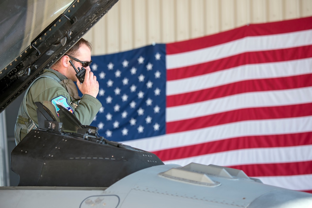 Pilot Capt. Phillip Butler performs a radio call as he waits to launch an F-16.