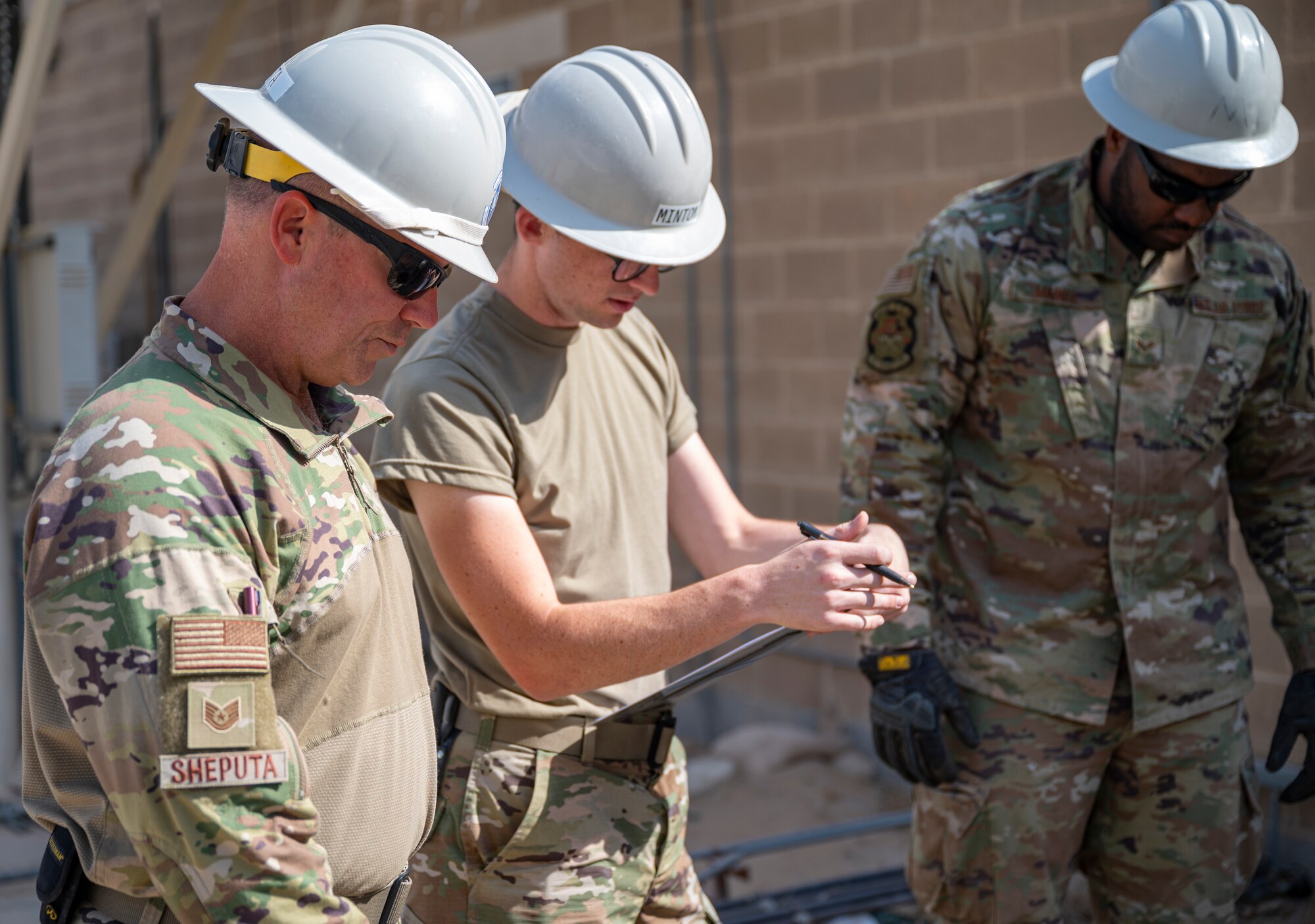 Members of the U.S. Air Forces Central, Air Force Forces A67 Engineering and Installation team observe a communications maintenance hole at Ali Al Salem Air Base, Kuwait, Oct. 19, 2021.
